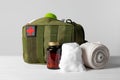 Military first aid kit, medical cotton, pills and elastic bandage on white wooden table Royalty Free Stock Photo