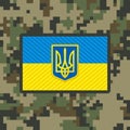 Military flag patch of the Ukrainian army on pixel camouflage background