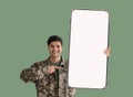 Military guy showing nice smartphone with empty screen Royalty Free Stock Photo