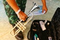 The military hand is holding the instrument.  Silver trumpet dryer type with black box on the floor Royalty Free Stock Photo