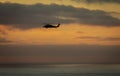 A military helicopter flying toward the left in a cloudy sunset Royalty Free Stock Photo