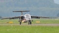 Military jet airplane taxiing on the runway with lights on in a green background Royalty Free Stock Photo