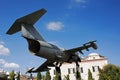 A military jet fighter flying over a building