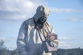 A military man in a chemical protection suit measures radiation with a dosimeter standing in front of a barrier. Royalty Free Stock Photo