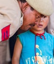 Military man comforting a crying baby boy