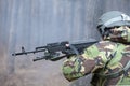 Military man shooting a rifle in the forest