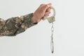 a military man is holding handcuffs