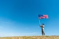 Military man in uniform looking at american flag with stars and stripes