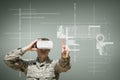 Military man in VR headset touching interface against green background with interfaces Royalty Free Stock Photo