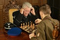 Military mature men on the table playing chess