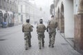 Military mens patroling in the street whit shotguns