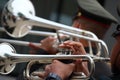 Military musicians performing trumpets and trombones, optional focus outdoor marching band.