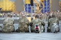 Military musicians sitting backs after parade, blurred people on a background