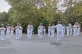 Military navy band in ceremonial white suits performs in the city park