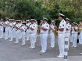 Military navy band in ceremonial white suits performs in the city park