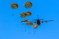 Military parachutist paratroopers parachute jumping out of a air force planes on a clear blue sky day Royalty Free Stock Photo