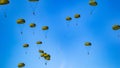 Military parachutist paratroopers parachute jumping out of a air force planes on a clear blue sky day with the moon