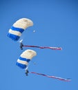 Military Parachutists jumping and landing together.