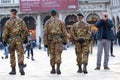 Military patrol walking near photographer in Piazza San Marco in Venice