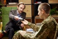 Military person having therapy session. Psychologist consults female soldier. Post-traumatic syndrome, specialist help Royalty Free Stock Photo