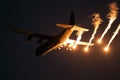 Military plane firing flares during a  night flight Royalty Free Stock Photo