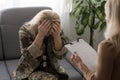 Military psychiatry concept. soldier lady sitting on couch during therapy session, woman in military uniform having