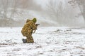 A military soldier in camouflage with a weapon goes on the offensive in winter