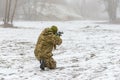 A military soldier in camouflage with a weapon goes on the offensive in winter