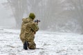 A military soldier in camouflage with a weapon goes on the offensive in winter