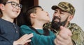 Military soldier having tender moment together his son with disability at home