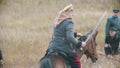 Military soldier is riding a horse with weapon in his hand