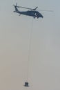 Military team in conflict resucing people by helicopter. flying through the air on a rope attached to chopper in the smoke and