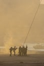 Military team in conflict resucing people by helicopter. Getting loaded on a rope attached to chopper in the smoke and haze in the