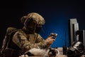 Military in uniform sitting at a computer conducts cyber warfare Royalty Free Stock Photo