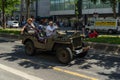 Military utility vehicle Willys MB of the time of the World War II moving on the street with passengers.