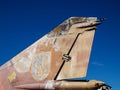 Military war jet airplane tail with Ukrainian air defense logo against blue sky. Old, worn out and rough metal surface painted in Royalty Free Stock Photo