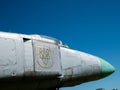 Military war jet airplane tail with Ukrainian air defense logo against blue sky. Old, worn out and rough shiny metal surface. Royalty Free Stock Photo