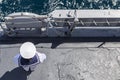 Sailor in white uniform standing peacefully on the deck of a warship.