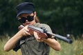 Military woman Weapon in hand aiming hunting sunglasses green leaves Royalty Free Stock Photo