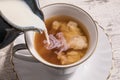 Milk being poured into a cup of hot tea Royalty Free Stock Photo
