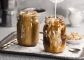 Milk Being Poured Into a Glass of Iced Coffee