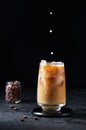 Milk Being Poured into Iced Coffee in Tall Glass on Dark Background. Concept Refreshing Summer Drink Royalty Free Stock Photo