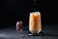 Milk Being Poured into Iced Coffee in Tall Glass on Dark Background. Concept Refreshing Summer Drink Royalty Free Stock Photo