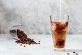 Milk Being Poured into Iced Coffee in Tall Glass on Light Grey Background. Concept Refreshing Summer Drink Royalty Free Stock Photo