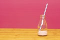 Milk bottle with dregs of strawberry milkshake and a straw Royalty Free Stock Photo
