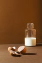 Milk in a bottle with eggs shells on brown background Royalty Free Stock Photo