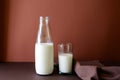 Milk bottle and milk glass on brown paper background. Royalty Free Stock Photo