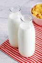 Milk bottles and cereal corn flakes on wooden table Royalty Free Stock Photo