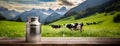 A milk can sits on a wooden deck overlooking a pastoral scene with grazing cows. The image brings to life rural charm