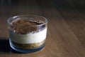 Milk cheesecake, decorated with coffee crumbs, on a wooden table on a blurred background in the early summer morning